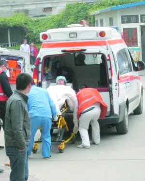 救援人员将伤者抬上急救车。新华社记者 罗晓光 摄