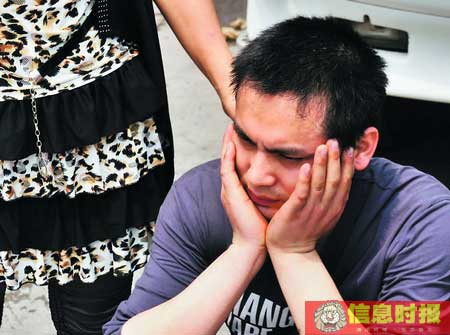 损失了几百万元的尹先生一脸愁容，他的妻子则在一旁安慰。